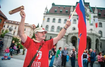 Z flagą Socjalistycznej Republiki Słowenii (kiedyś części Jugosławii) i marszałkiem Tito na koszulce: podczas demonstracji przeciwko korupcji wśród polityków. Lublana, 2013 r. / Fot. Jure Makovec / AFP PHOTO / EAST NEWS