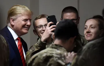 Donald Trump pozuje do zdjęć z amerykańskimi żołnierzami podczas wizyty zorganizowanej z okazji Święta Dziękczynienia w Afganistanie, 28 listopada 2019 r. Fot. OLIVIER DOULIERY/AFP/East News / 
