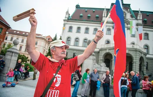 Z flagą Socjalistycznej Republiki Słowenii (kiedyś części Jugosławii) i marszałkiem Tito na koszulce: podczas demonstracji przeciwko korupcji wśród polityków. Lublana, 2013 r. / Fot. Jure Makovec / AFP PHOTO / EAST NEWS