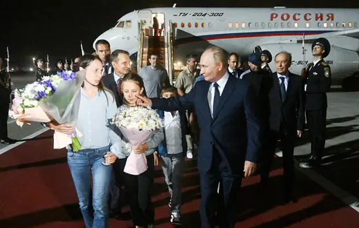 Na zdjęciu opublikowanym przez rosyjską agencję państwową Sputnik prezydent Rosji Władimir Putin wita obywateli Rosji uwolnionych w ramach wymiany więźniów z Zachodem, na pierwszym planie Anna i Artiom Dulcewowie oraz ich dzieci. Lotnisko Wnukowo, Moskwa, 1 sierpnia 2024 r. // Fot. Kirill Zykov / AFP / East News