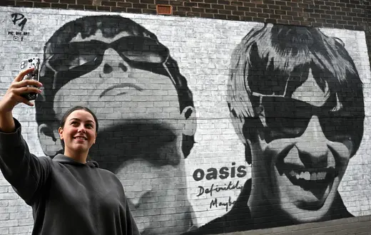 Mural przedstawiający członków zespołu Oasis: Liama ​​i Noela Gallagherów, wykony przez artystę z Manchesteru Pic.One.Art. N/z fanka zespołu Emily McShane. Burnage, przedmieścia Manchesteru, 27 sierpnia 2024 r. // Fot. Paul Ellis / East News