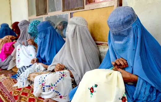 Afgańskie kobiety ubrane w burki podczas kursu haftowania. Kandahar, 4 września 2024 r. // Fot. Anaullah Seiam / AFP East News