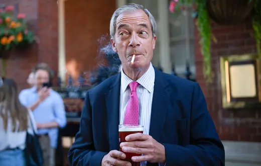 Nigel Farage, lider partii Reform UK, kreuje się na typowego Brytyjczyka. Tu ostentacyjnie pali przed pubem w reakcji na zapowiedź rządu Starmera, że chce zaostrzyć przepisy dotyczące palenia w pubach. Londyn, sierpień 2024 r. // Fot. Carl Court/ Getty Images