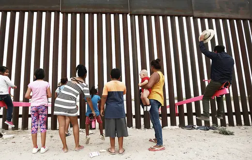Huśtawki przerzucone przez płot na granicy między Meksykiem a USA (instalacja artystyczna). Ciudad de Juarez, lipiec 2019 r. // Fot. Christian Chavez / AP / East News