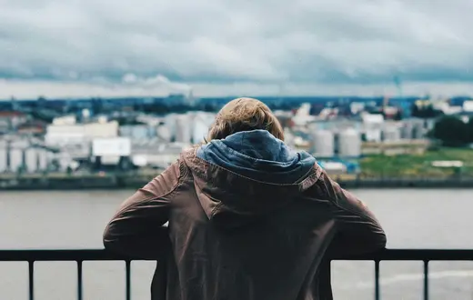 Osoba patrząca na miasto z balkonu – moment zatrzymania i refleksji, zdjęcie ilustracyjne Co sądzimy o pomocy psychicznej // Fot. Max Kukurudziak/ źródło: unsplash