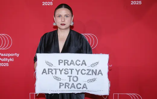 Monika Drożyńska z haftem „Praca artystyczna to praca", symbolizującym debatę o wynagrodzeniach dla artystów. Gala Paszportów Polityki 2025., 10 stycznia 2026 r. // Fot. Rafał Guz / PAP