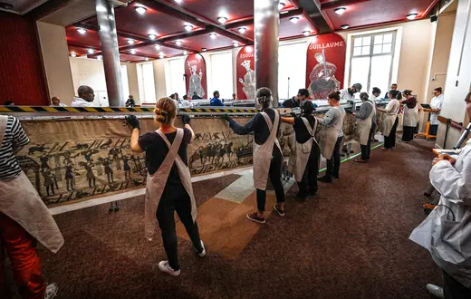 Pracownicy i wolontariusze przygotowują się do zapakowania Tkaniny z Bayeux do kontenerów, w których zostanie przewieziona do Muzeum Brytyjskiego w Londynie. Bayeux, 18 września 2025 roku. // Fot. Lou Benoist / Pool / AFP / East News