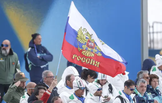 Kibice z rosyjskimi flagami podczas ceremonii medalowej biegu paraolimpijskiego mężczyzn na 20 km. Zwycięzca, rosyjski zawodnik Iwan Gołubkow, rywalizował jako sportowiec neutralny, zgodnie z zasadami obowiązującymi rosyjskich uczestników igrzysk. Włochy Val di Fiemme (Tesero), Włochy, 15 marca 2026 r. // Fot. Darrian Traynor / Getty Images
