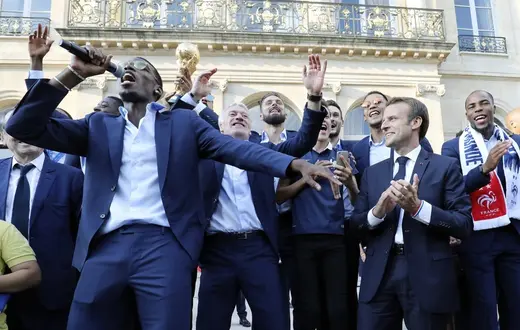 Paul Pogba (z mikrofonem) i pozostali reprezentanci Francji podczas przyjęcia przez Emmanuela Macrona (drugi z prawej) w Pałacu Prezydenckim, po powrocie drużyny ze zwycięskiego mundialu, 16 lipca 2018 / Fot. Ludovic Marin / AFP / East News / 