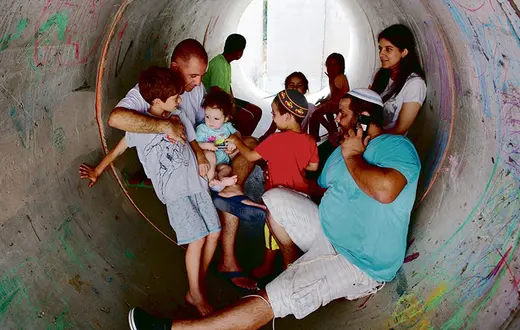 Izraelczycy ze wsi Nitzan w południowej części Izraela chronią się w przepuście wodnym przed palestyńskim ostrzałem z Gazy. 10 lipca 2014 r. / Fot. Menahem Kahana / AFP / EAST NEWS