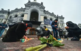 Przed operą w Kijowie, w rocznicę nalotu na teatr w Mariupolu, w którym zginęło kilkuset cywilów, ludzie układają ze świec słowo „Dzieci”. 16 marca 2023 r.  / SERGEI SUPINSKY / AFP / EAST NEWS / 