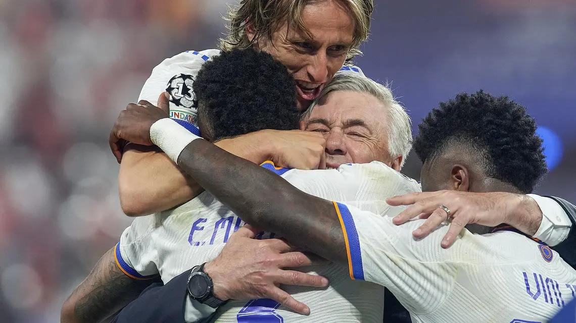 Trener Realu Carlo Ancelotti świętuje zwycięstwo w finale Ligi Mistrzów z Luką Modriciem, Viniciusem Juniorem i Ederem Militao. Paryż, 28 maja 2022 r. / FOT. Jose Breton / Pics Action / NurPhoto via Getty Images / 