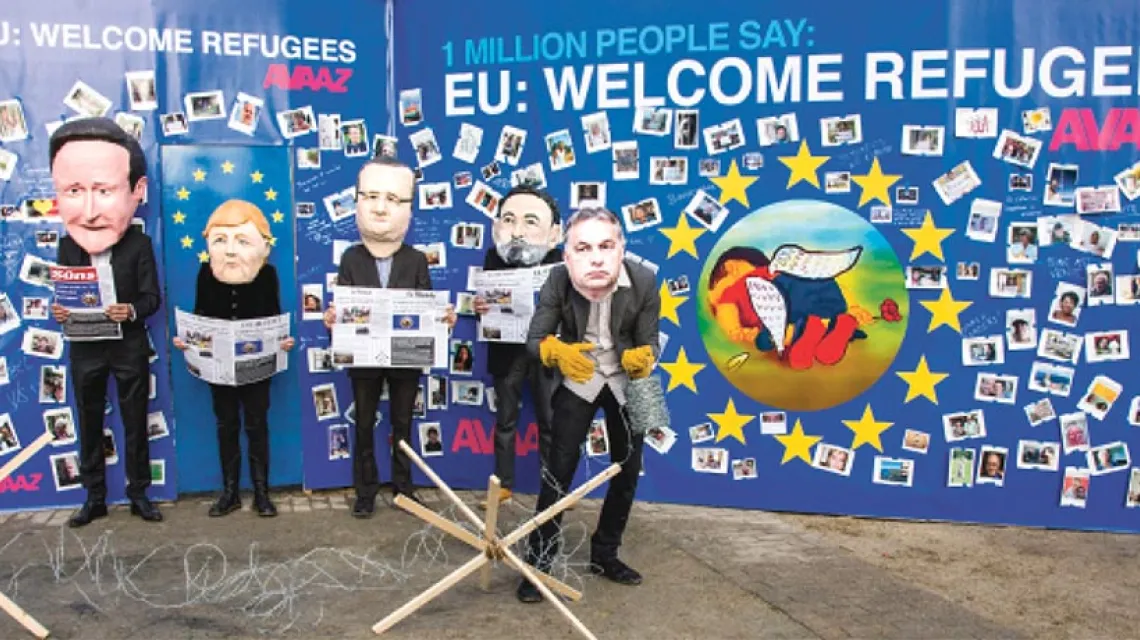 Aktorzy przebrani za unijnych polityków trzymają okładki gazet, w których ukazało się zdjęcie Aylana Kurdiego, 3-latka, który utonął podczas przeprawy do Europy. Bruksela, 14 września 2015 r. / Fot. Virginia Mayo / AP / EAST NEWS