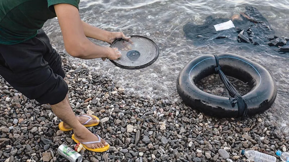 Uchodźca myje naczynia na plaży w centrum miasta. / Fot. Łukasz Zakrzewski