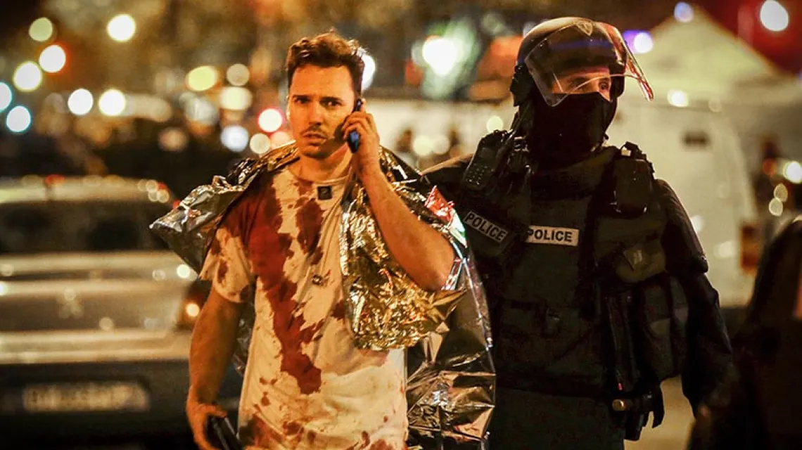 Policjant eskortujący ocalałego z zamachu w paryskim klubie Bataclan, 13 listopada 2015 r.  / Fot. Philippe Wojazer / REUTERS / FORUM