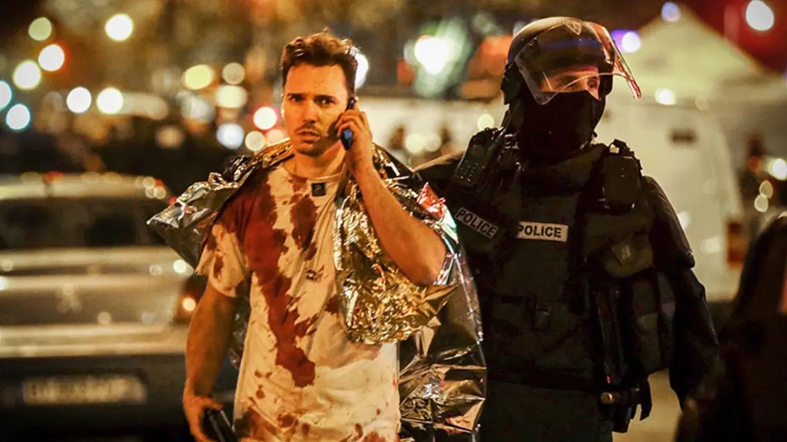 Policjant eskortujący ocalałego z zamachu w paryskim klubie Bataclan, 13 listopada 2015 r. / Fot. Philippe Wojazer / REUTERS / FORUM