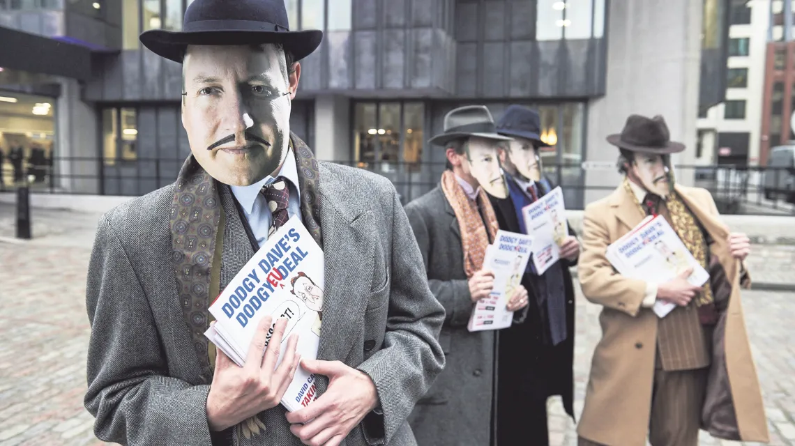 „Krętacki deal krętackiego Dave’a”? Antyunijni aktywiści pozują do zdjęć w maskach z twarzą premiera Davida Camerona, Londyn, 19 lutego 2016 r. / Fot. Niklas Halle'n / AFP / EAST NEWS