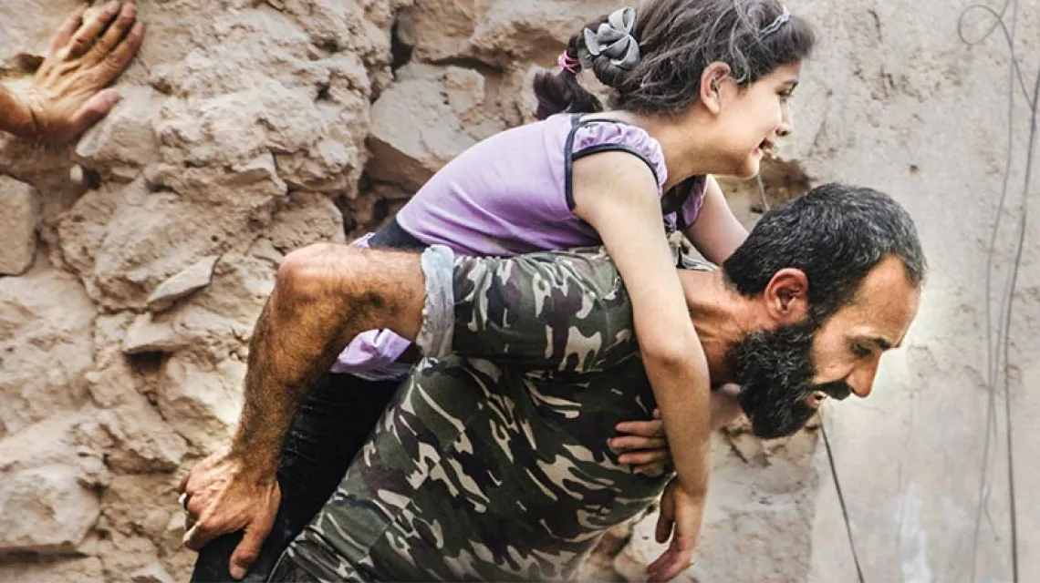 Syryjski powstaniec i dziewczynka ranna w nalocie na wschodnią, pozostającą pod kontrolą opozycji, część Aleppo. 8 lipca 2016 r.  / Fot. Abdalrhman Ismail / REUTERS / FORUM