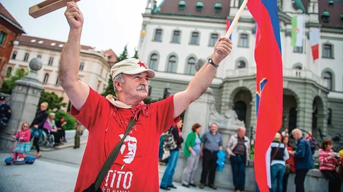 Z flagą Socjalistycznej Republiki Słowenii (kiedyś części Jugosławii) i marszałkiem Tito na koszulce: podczas demonstracji przeciwko korupcji wśród polityków. Lublana, 2013 r. / Fot. Jure Makovec / AFP PHOTO / EAST NEWS