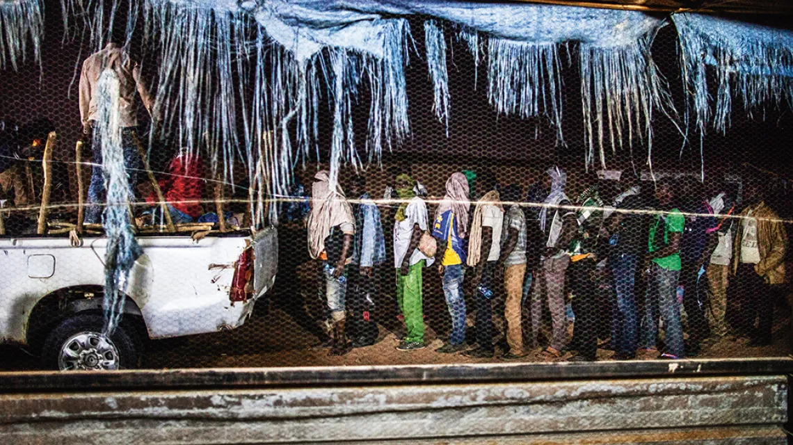 Imigranci z Afryki subsaharyjskiej w kolejce do samochodu przemytników, który zabierze ich do Libii.  Kolejki, mimo informacji o niewolnictwie w tym kraju, ustawiają się do dziś. Agadez, Niger, 2015 r. / THE WASHINGTON POST / CONTRIBUTOR / GETTY IMAGES
