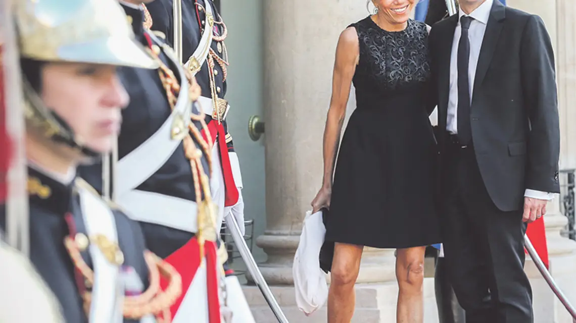 Emmanuel Macron z żoną przybywają na przyjęcie, którym prezydent Hollande uhonorował w Pałacu Elizejskim hiszpańską parę królewską. Paryż, 2015 r. / Fot. Jean Catuffe / GETTY IMAGES