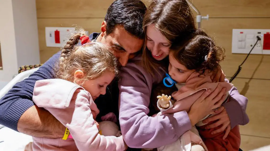 Yoni Asher wita się z żoną Dorą i córkami Aviv i Raz, które przez 48 dni były w niewoli Hamasu. Fotografia udostępniona przez Schneider Children Medical Centre, Tel Awiw, 25 listopada 2023 r. / Fot. Schneider Hospital Spokesperson's Office / AFP / East News