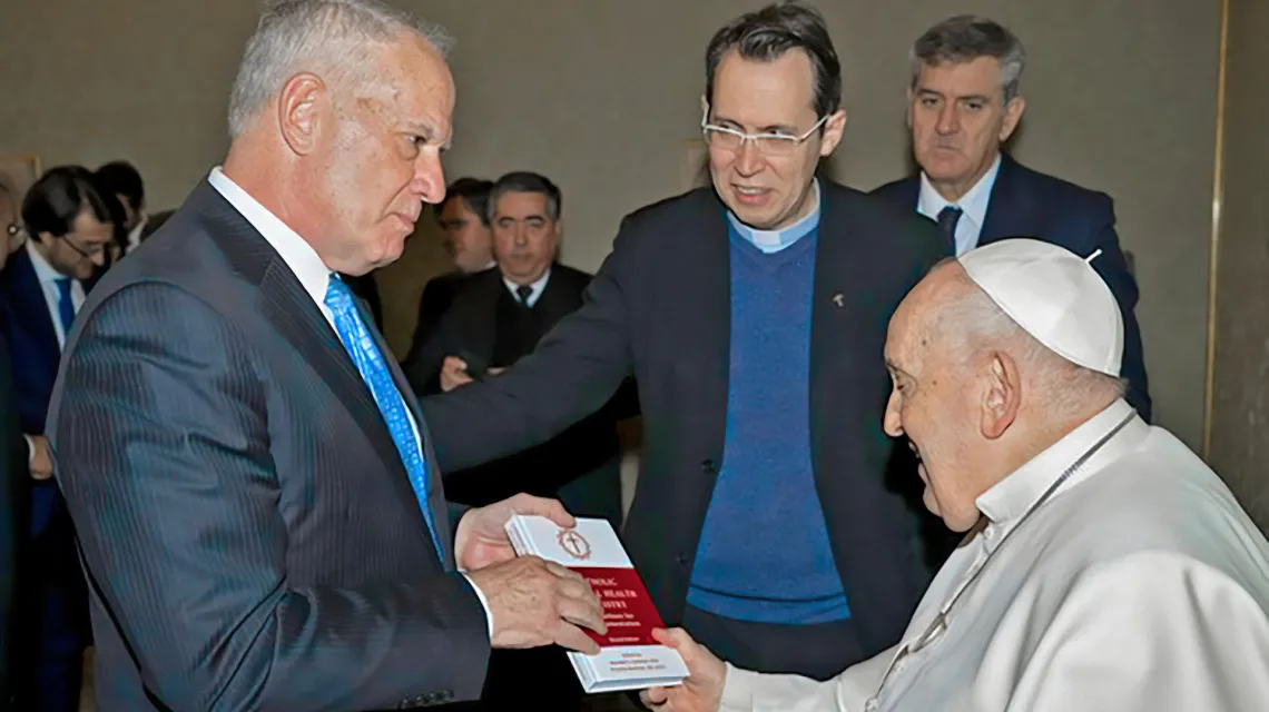 Diakon Ed Schoener przekazuje papieżowi Franciszkowi opracowany przez jego stowarzyszenie podręcznik dla duszpasterzy zdrowia psychicznego, Watykan, 26 stycznia 2024 r. // Fot. Association of Catholic Mental Health Ministers