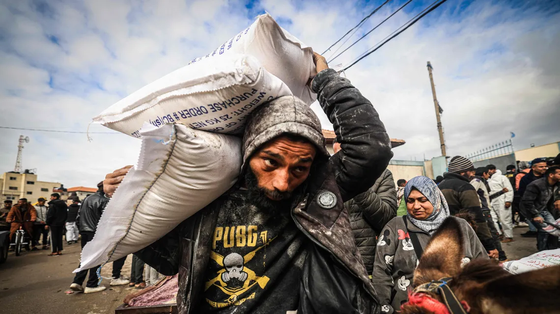 Palestyńczycy wysiedleni do Rafah otrzymują pomoc żywnościową ze środków Agencji Narodów Zjednoczonych ds. Pomocy i Pracy dla Uchodźców Palestyny. Rafah, Strefa Gazy, 28 stycznia 2024 r. / fot. AFP / EAST NEWS