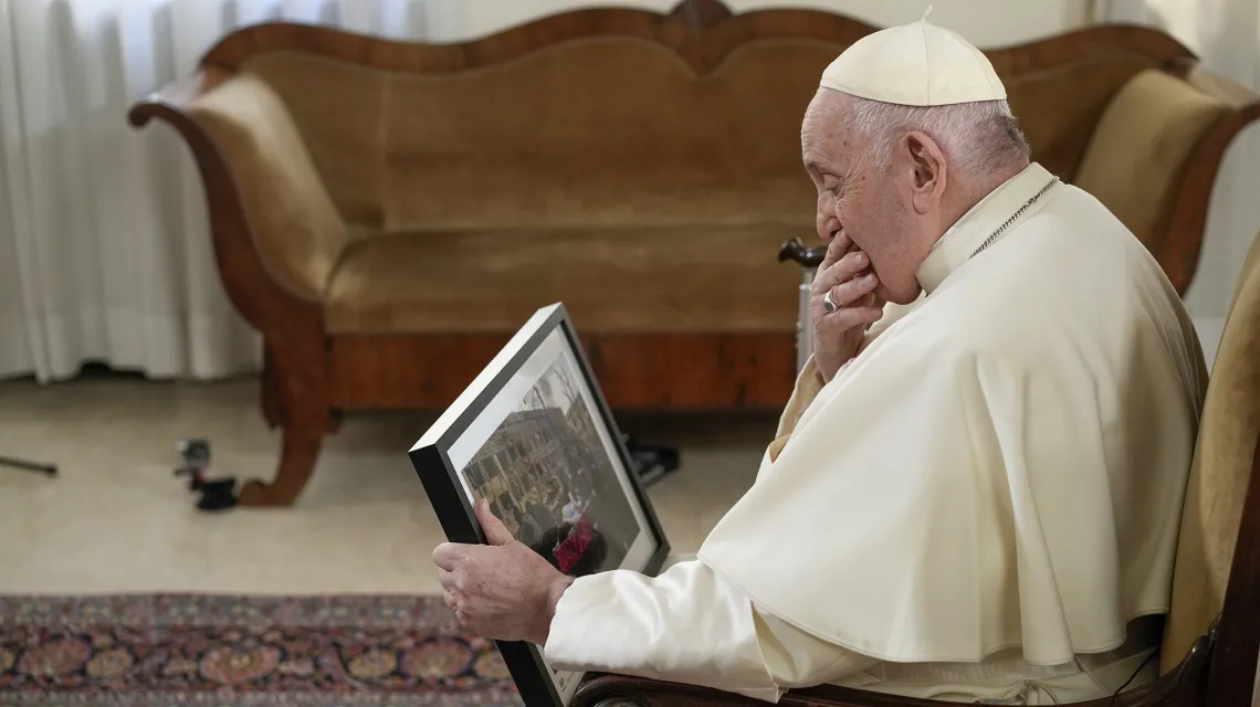 Papież patrzy na zdjęcie zniszczonego Mariupola, Watykan, styczeń 2023 r. // Fot. Andrew Medichini / AP / East News