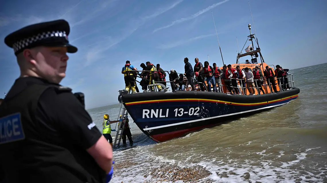Kuter Royal National Lifeboat Institution z imigrantami przybija do wybrzeża Anglii niedaleko Dungeness, czerwiec 2022 r. // Fot. Ben Stansall / AFP / East News