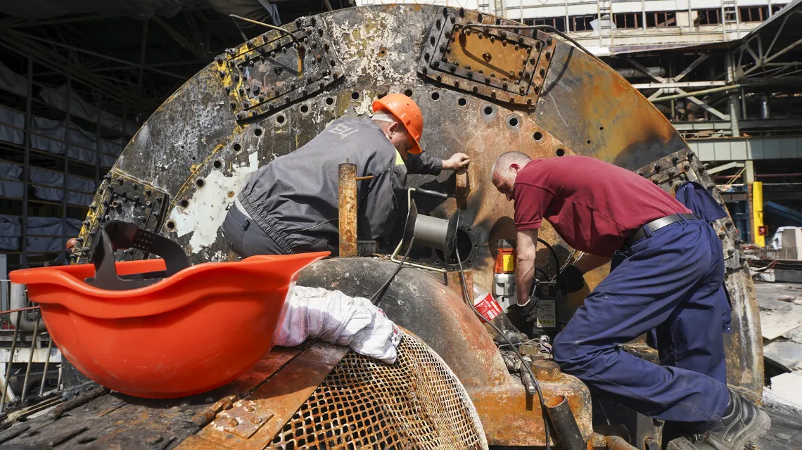 Pracownicy naprawiają elektrownię zniszczoną przez rosyjskie rakiety w pobliżu Charkowa. Ukraina, 12 kwietnia 2024 r. // Fot. Andrii Marienko / AP / East News
