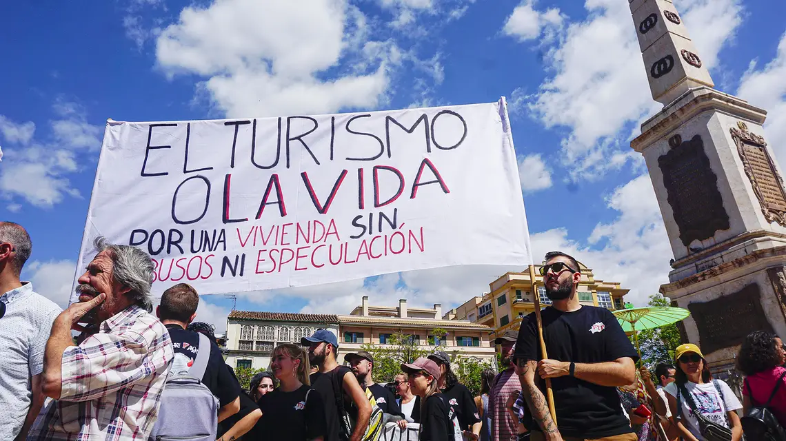 Protest mieszkańców Malagi przeciwko masowej turystyce. Na transparencie napis "Turystyka lub życie. Za mieszkanie bez nadużyć i spekulacji". Malaga, 29 czerwca 2024 r. // Fot. Agnieszka Zielińska