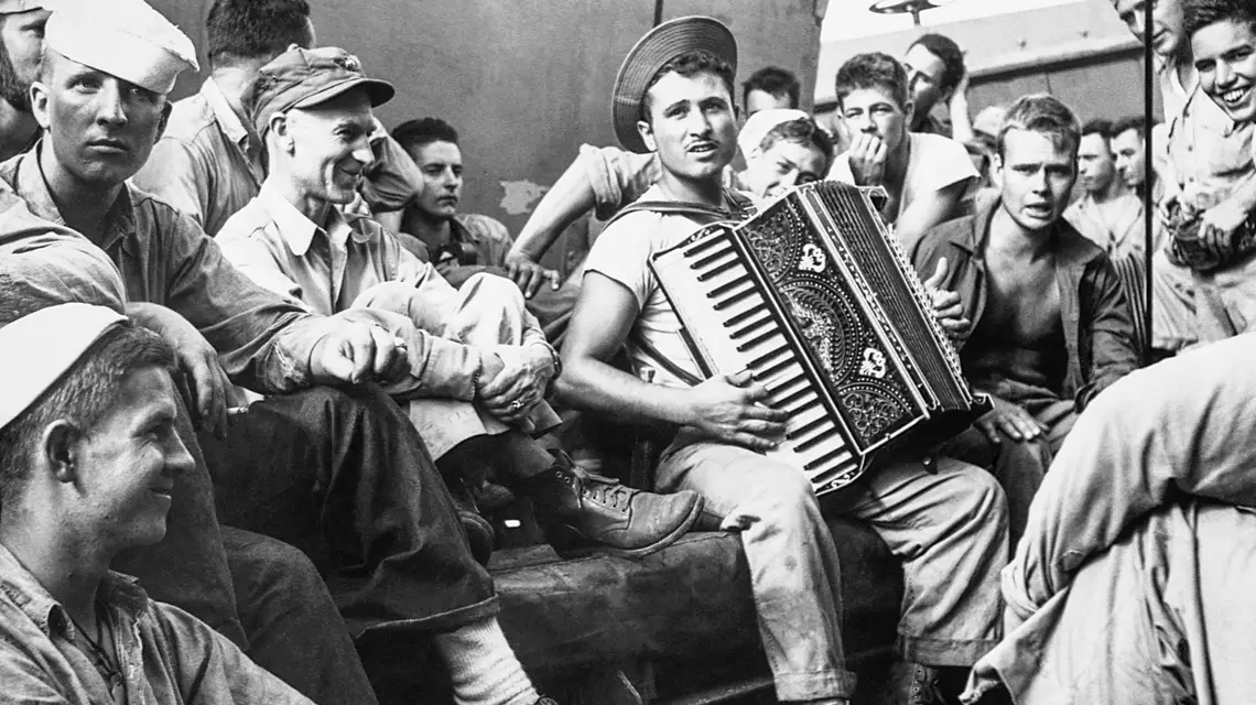 Ernie Pyle (w czapce z daszkiem) wśród marynarzy Floty Pacyfiku Stanów Zjednoczonych kierującej się na Okinawę, 1945 r. // Fot. Corbis / Getty Images