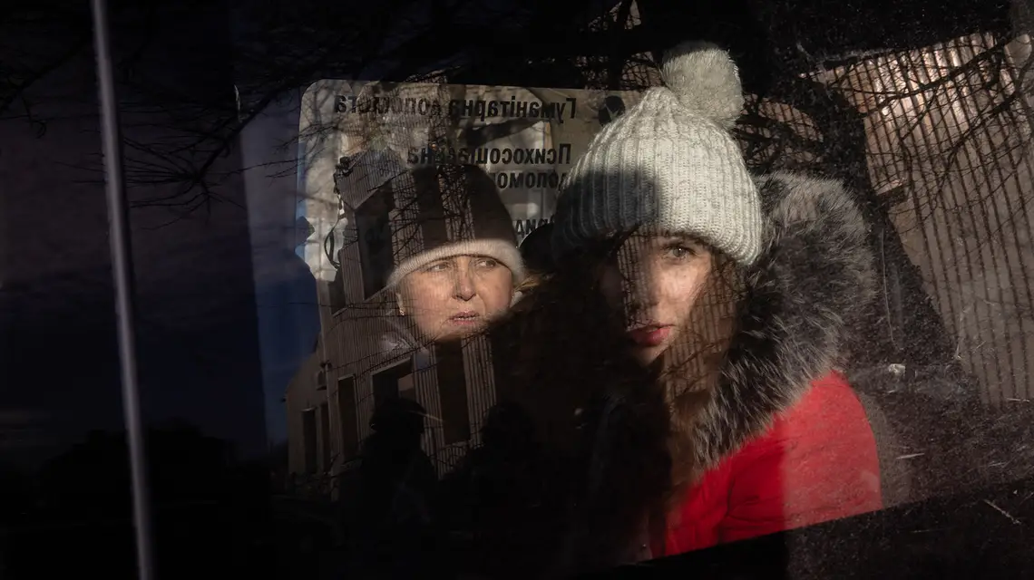 Anna z matką czekają w busie na ewakuację z Pokrowska. Rosjanie są coraz bliżej tego miasta w obwodzie donieckim, trwa przymusowa ewakuacja ostatnich mieszkańców. 14 grudnia 2024 r. // Fot. Roman Pilipey / AFP / East News