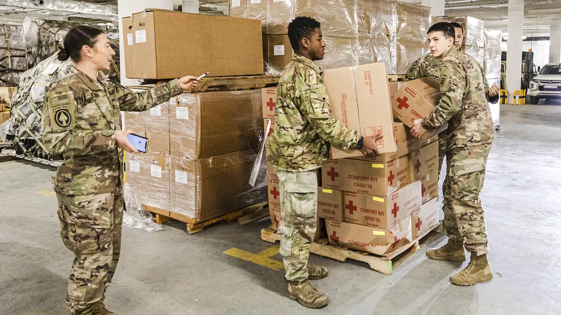 Spadochroniarze 82. Dywizji Powietrznodesantowej pomagają w rozładunku pomocy humanitarnej USAID na rzecz osób ewakuowanych z Ukrainy. Rzeszów, 25 lutego 2022 r. // Fot. Sgt. Robert Whitlow / U.S.Army / AP / East News