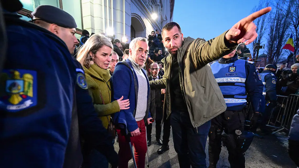 Kandydat na prezydenta Calin Georgescu wraz z żoną Cristelą opuszczają siedzibę Prokuratury Generalnej w Bukareszcie. Rumunia, 26 lutego 2025 r. // Fot. Daniel Mihailescu / AFP / East News