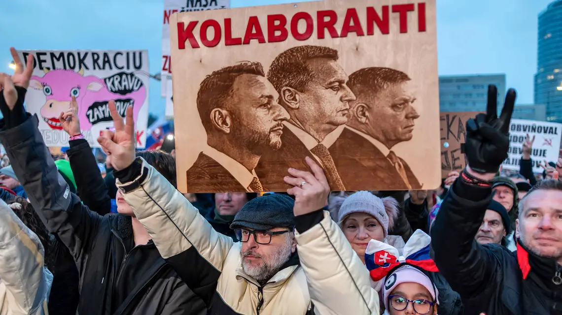 Antyrządowy protest w Bratysławie, 7 lutego 2025 r. Pod oskarżeniem o kolaborację z Rosją widnieją podobizny premiera Ficy (z prawie) i liderów ugrupowań koalicyjnych: Matúša Eštoka (partia Hlas; z lewej) i Andreja Danko (Słowacka Partia Narodowa; w środku). Słowacja 7 lutego 2025 r. // Fot. Tomas Benedikovic // AFP / East News