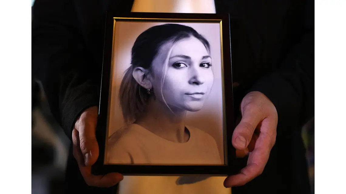 Ukraińska dziennikarka Wiktoria Roszczyna pisała reportaże z terenów okupowanych. Aresztowana, została zamęczona w areszcie. Na zdjęciu: kolega Wiktorii z jej zdjęciem podczas uroczystości, która odbyła się po tym, jak Rosjanie poinformowali o jej śmierci. Plac Niepodległości w Kijowie, 11 października 2024 r. // Fot. Anatolii Stepanov / AFP / East News
