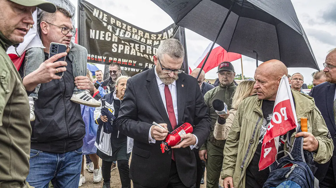 Grzegorz Braun po zakłóceniu obchodów rocznicowych w Jedwabnem składał na gaśnicach autografy dla swoich zwolenników. Jedwabne, 10 lipca 2025 r. // Fot. Marek Maliszewski / Reporter