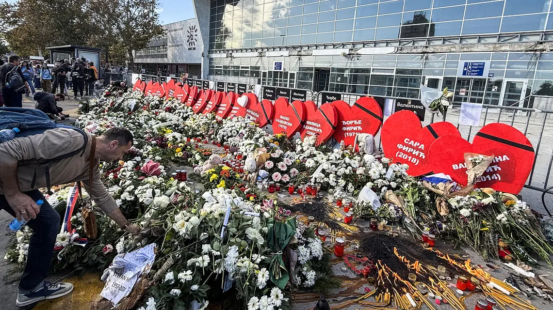 Kwiaty złożone w hołdzie ofiar katastrofy w Nowym Sadzie, w tle budynek dworca, Nowy Sad, 1 listopada 2025 r. // Fot. Juliusz Pielichowski
