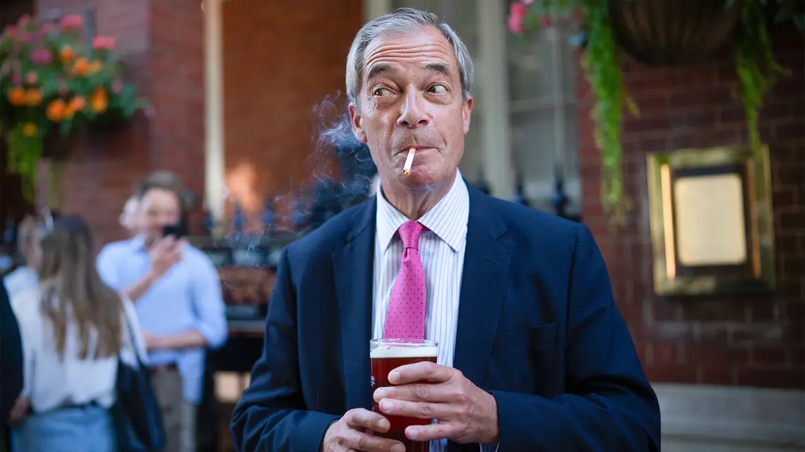 Nigel Farage, lider partii Reform UK, kreuje się na typowego Brytyjczyka. Tu ostentacyjnie pali przed pubem w reakcji na zapowiedź rządu Starmera, że chce zaostrzyć przepisy dotyczące palenia. Londyn, sierpień 2024 r. // Fot. Carl Court/ Getty Images