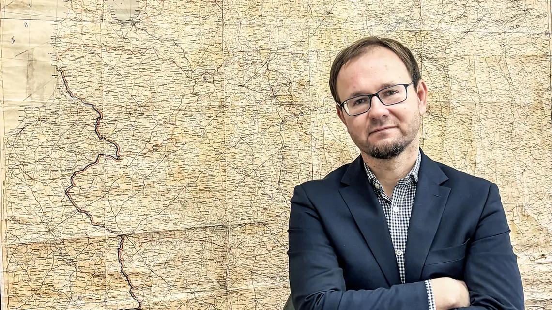xWojciech Konończuk w siedzibie Ośrodka Studiów Wschodnich. W tle sowiecka mapa z wyrysowaną linią graniczną paktu Ribbentrop-Mołotow. Warszawa, listopad 2025 r. // Fot. Michał Okoński 