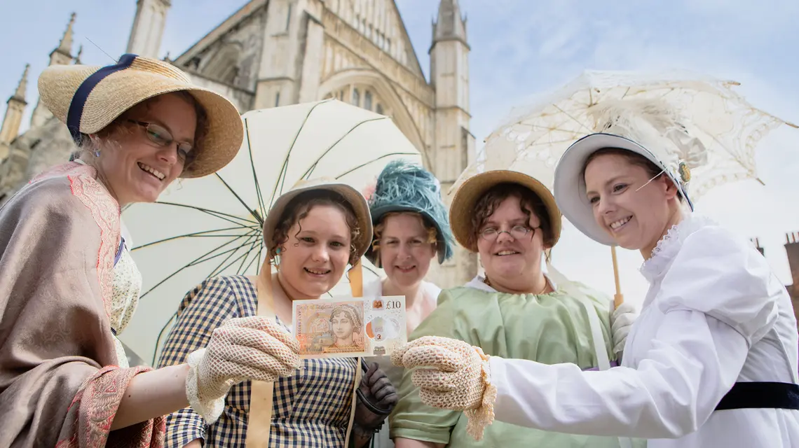 „Austenmania” – fascynacja twórczością i postacią Jane Austen – przybiera różne formy: jej wielbicielki w strojach z epoki prezentują 10-funtowy banknot, wydany właśnie z podobizną Austen. W tle katedra w Winchesterze, gdzie pisarka została pochowana. Lipiec 2017 r. // Fot. Steve Parsons / PA / Getty Images