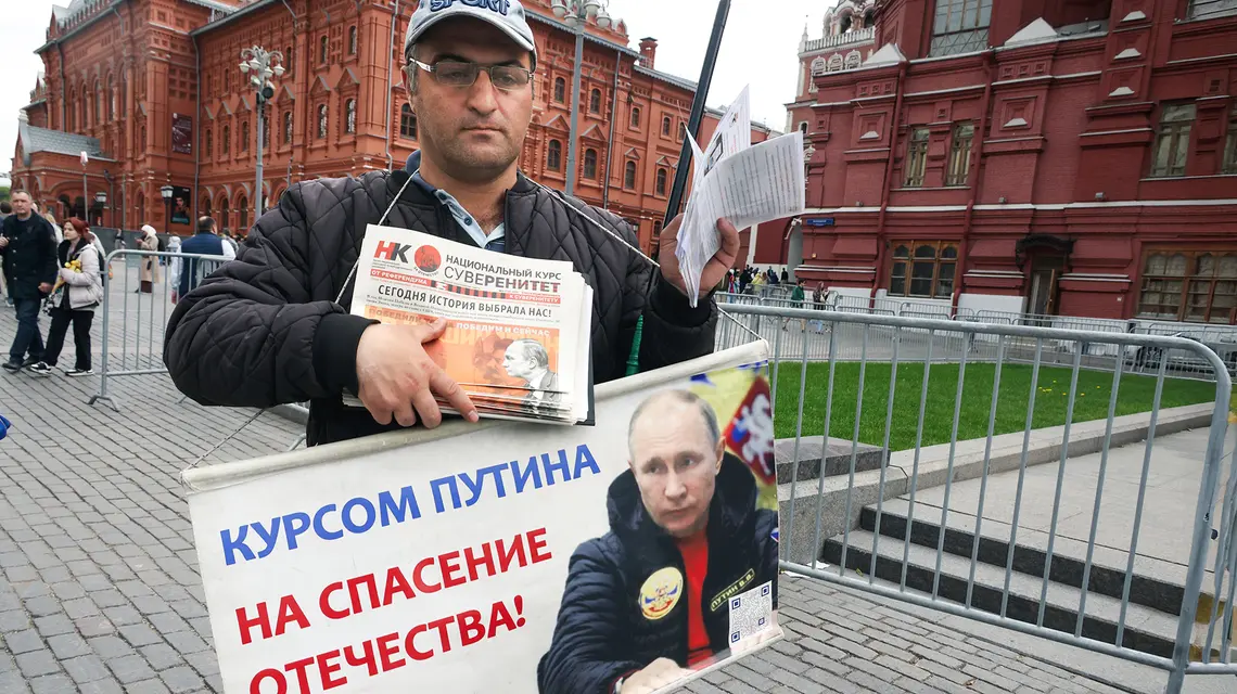 Prokremlowski aktywista z transparentem „Kursem Putina na zbawienie ojczyzny”. Moskwa, maj 2025 r. // Fot. Getty Images