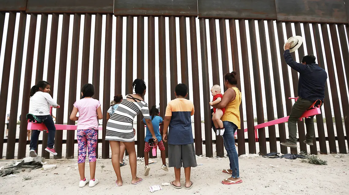 Huśtawki przerzucone przez płot na granicy między Meksykiem a USA (instalacja artystyczna). Ciudad de Juarez, lipiec 2019 r. // Fot. Christian Chavez / AP / East News