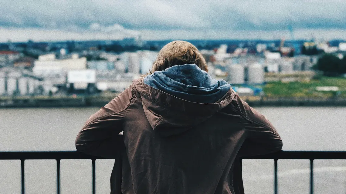 Osoba patrząca na miasto z balkonu – moment zatrzymania i refleksji, zdjęcie ilustracyjne Co sądzimy o pomocy psychicznej // Fot. Max Kukurudziak/ źródło: unsplash