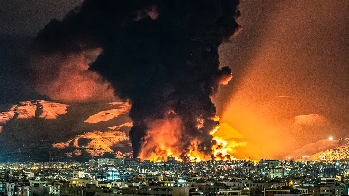 Toksyczne chmury nad stolicą Iranu w trakcie nalotu na rafinerię, położoną w północno-zachodniej części Teheranu. 7 marca 2026 r. // Fot. Sasan / Middle East Images / AFP / East News