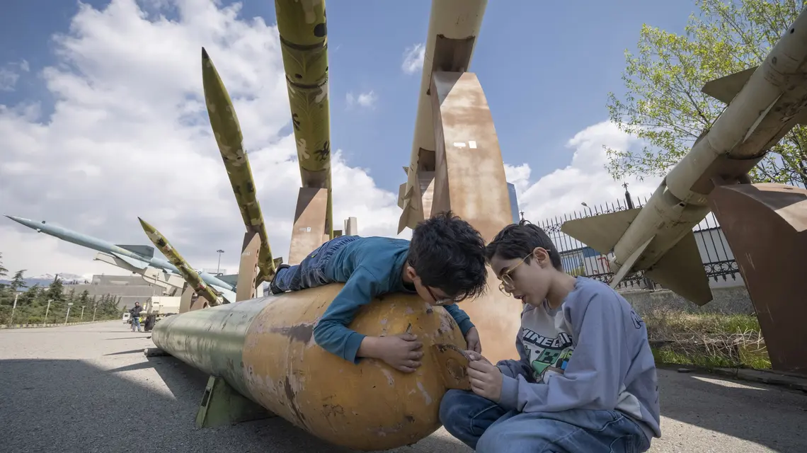 Irańscy chłopcy przed irańskimi pociskami rakietowymi w muzeum wojennym w Teheranie. 2 kwietnia 2026 r. // Fot. Morteza Nikoubazl / Getty Images