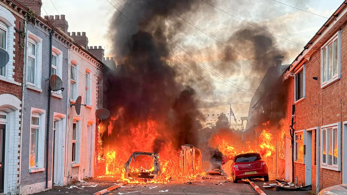 Samochody płonące na ulicach Belfastu. Podczas antyemigranckich zamieszek doszło do niszczenia mienia i przemocy wobec osób o ciemnej skórze. Belfast, 9 czerwca 2026 r. // Fot. PA / PAP