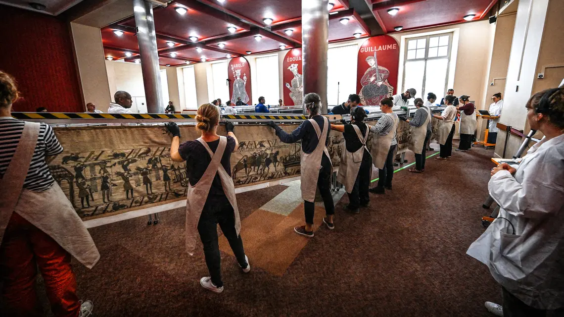 Pracownicy i wolontariusze przygotowują się do zapakowania Tkaniny z Bayeux do kontenerów, w których zostanie przewieziona do Muzeum Brytyjskiego w Londynie. Bayeux, 18 września 2025 roku. // Fot. Lou Benoist / Pool / AFP / East News 
